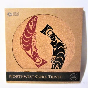 May include: A round cork trivet with a Northwest Coast design featuring two salmon, one red and one black, facing each other. The trivet is 7 inches in diameter and says "Northwest Cork Trivet" on the bottom.