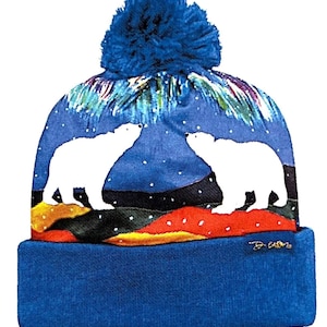 May include: Blue knit toque with a white polar bear silhouette design and a blue pom pom. The toque features a colorful aurora borealis pattern and a black and white landscape.
