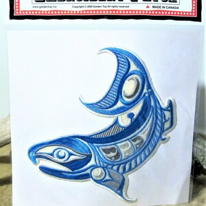 Può includere: Toppa ricamata blu e bianca di un salmone stilizzato con un design a forma di luna crescente. La toppa è su uno sfondo bianco e ha il testo "EMBROIDERY PATCH" nella parte superiore.