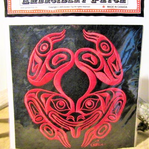 Può includere: Toppa ricamata rossa con una rana stilizzata su sfondo nero. La toppa è etichettata "Embroidery Patch" e "Made in Canada".