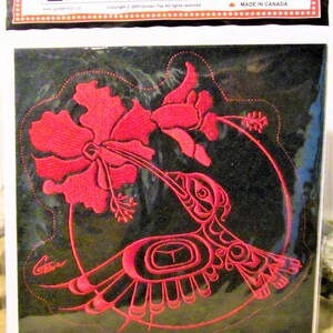 Può includere: Toppa ricamata rossa che raffigura un colibrì stilizzato con un fiore, su sfondo nero. La toppa è etichettata "Embroidery Patch" e "Made in Canada".