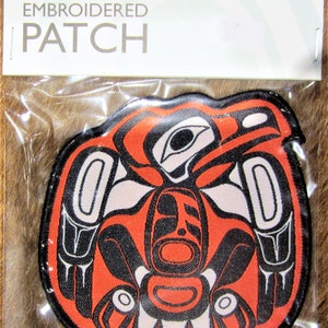 Può includere: Toppa ricamata da stirare con un designo stilizzato di un uccello in rosso, nero e bianco. La toppa è etichettata "iron-on EMBROIDERED PATCH".