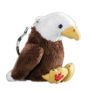 Könnte beinhalten: Ein brauner und weißer Plüsch-Weißkopfseeadler-Schlüsselanhänger mit einem roten Ahornblatt an seinem Fuß.