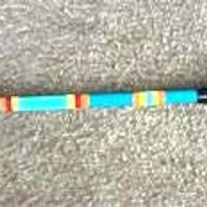 May include: A turquoise wooden mallet with a rounded head and a black, textured handle. The shaft has orange and yellow stripes. The mallet is designed for a game or craft.