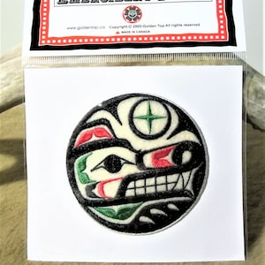 Könnte beinhalten: Ein gestickter Patch in Schwarz und Weiß mit einem stilisierten Tiergesicht. Das Gesicht hat rote und grüne Akzente und einen Stern in der Mitte. Der Patch ist rund und hat einen weißen Hintergrund. Der Text "EMBROIDERY PATCH" ist auf der Verpackung aufgedruckt.