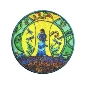 Può includere: Toppa rotonda ricamata raffigurante una donna in abito blu, circondata da libellule e fogliame. Il design presenta uno sfondo giallo a forma di sole e un bordo dettagliato con accenti verdi e blu. Per abbigliamento o accessori.