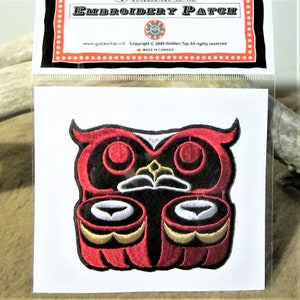 May include: Red, black, white and gold embroidered owl patch. The owl is stylised with a large beak and round eyes. The patch is in a clear plastic bag with a white backing card. The card has the text "Embroidery Patch" and "www.goldentop.ca Copyright © 2005-Golden Top All rights reserved Made in Canada."