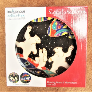 Può includere: Un piatto in ceramica da 1,5 pollici con sfondo nero e un design colorato di orsi polari che ballano. Il piatto fa parte della collezione Indigenous di CAP e presenta il testo "Dancing Bears & Three Bears" e "Dawn Oman".