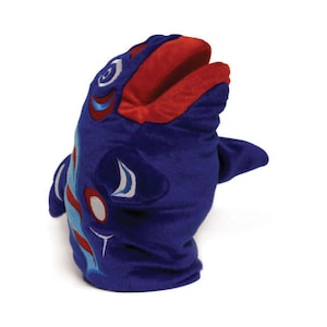 May include: Blue and red plush hand puppet shaped like a fish with a stylized design. The puppet has a large open mouth and a fin on the side.