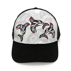 May include: A black and white baseball cap with a white front panel featuring a design of three stylized orcas in red, black, and white. The orcas are swimming in a pattern that resembles waves.
