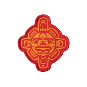 Peut inclure: Patch brodé rouge et orange avec un motif de visage de soleil stylisé. Le visage du soleil a un motif géométrique et est entouré d'une croix rouge.