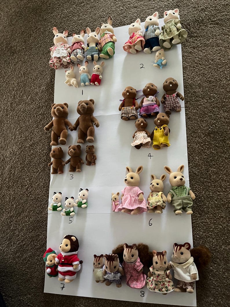 May include: A collection of flocked animal figurines arranged in groups on a white sheet, labelled with numbers 1 through 9. The set includes various rabbits, bears, squirrels, and other creatures wearing miniature fabric clothing in diverse colours.