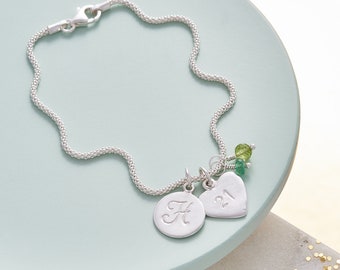 Personalised milestone birthday bracelet in silver with birthstones, heart number charm and circle initial disk charm
