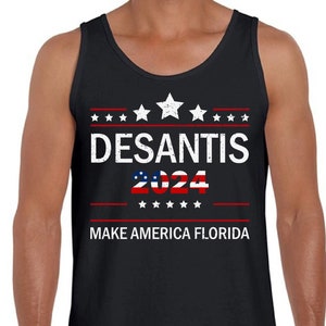May include: Black tank top with white text that reads "DESANTIS 2024" with red stars and stripes above and below the text. The text "MAKE AMERICA FLORIDA" is below the stars and stripes.