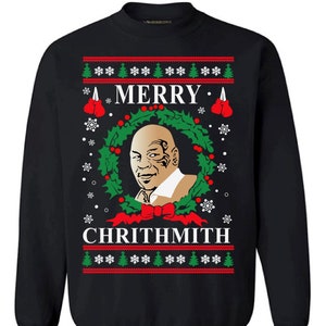 May include: Black Christmas sweater with a green wreath, red bow, and a portrait of a man with a black eye. The sweater has the text "Merry" and "Chrithmith" on it.