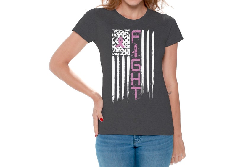 May include: A dark heather grey t-shirt with a pink ribbon and the word "FIGHT" printed on a white distressed American flag design.