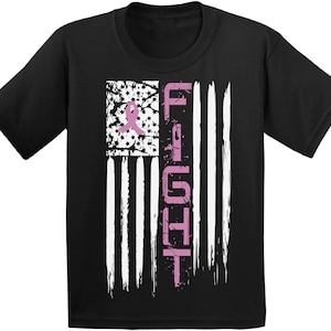 Pu&ograve; includere: Maglietta nera con un nastro rosa e la parola "FIGHT" su un design di bandiera americana usurato.