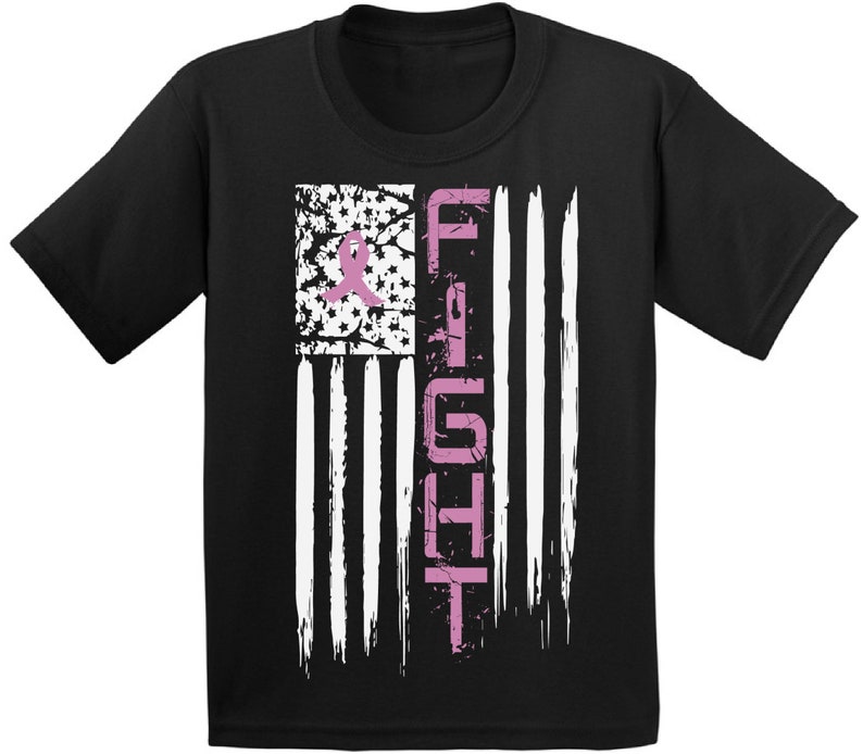 Pu&ograve; includere: Maglietta nera con un nastro rosa e la parola "FIGHT" su un design di bandiera americana usurato.