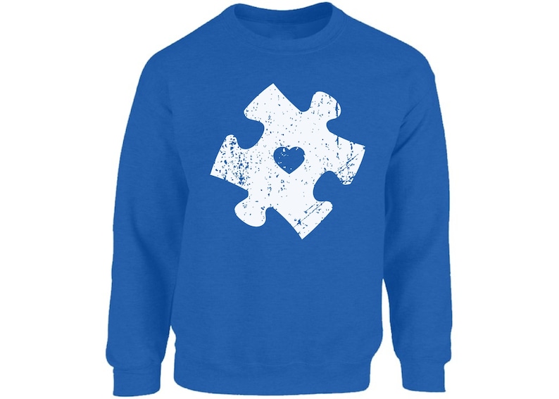 May include: A royal blue sweatshirt with a white distressed jigsaw piece design featuring a small heart in the centre.