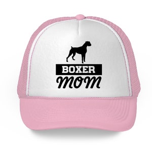 Może przedstawiać: R&oacute;żowa i biała czapka trucker z czarną sylwetką boksera i napisem "BOXER MOM" w kolorze czarnym.