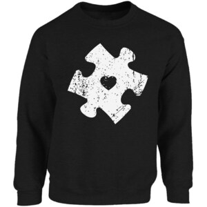 May include: Black sweatshirt with a white distressed jigsaw piece design featuring a small heart in the centre.