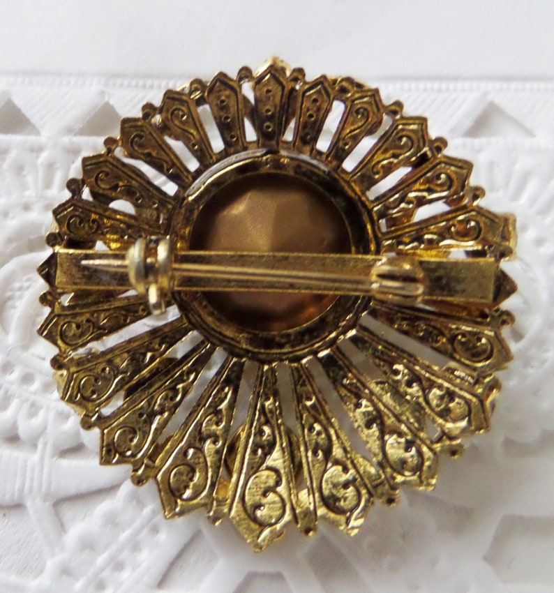 Vintage Round Ornate Gold-tone Brooch With Small Clear Rhinestones And Large Round Faceted Topaz Colored Center Stone