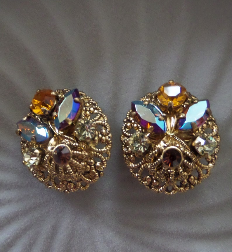 Vintage Round Circle Ornate Gold Tone Filigree Clip On Earrings with Dazzling Aurora Borealis Rhinestones Made In West Germany