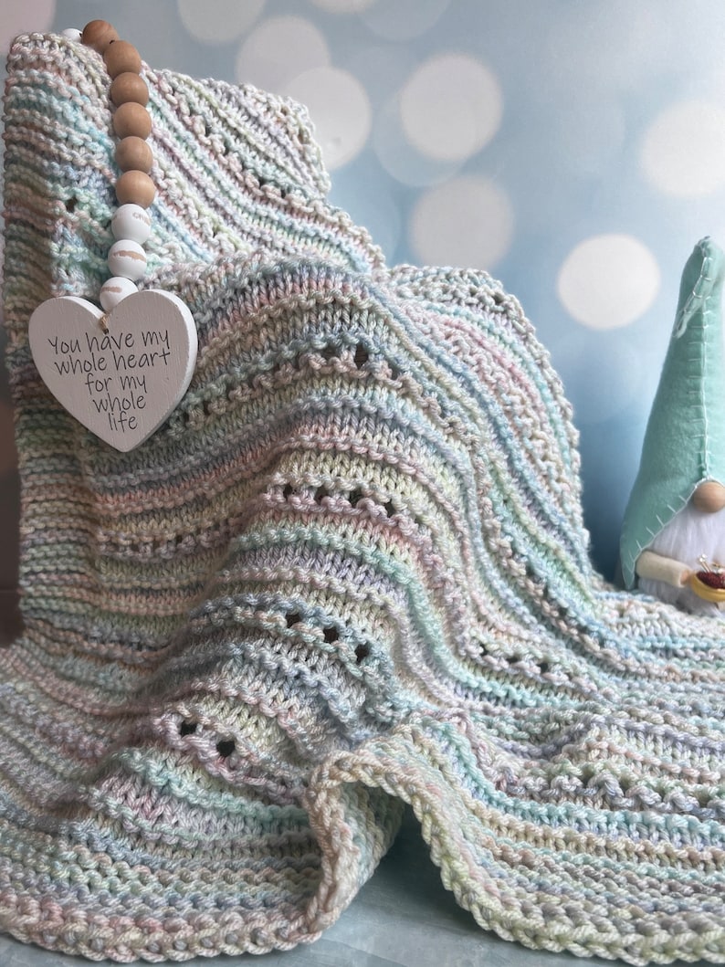 May include: A soft, multi-colored knitted baby blanket with a heart-shaped tag that reads "You have my whole heart for my whole life".
