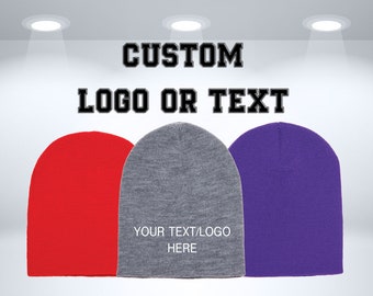 May include: Three knit beanies in red, gray, and purple. The gray beanie has the text "YOUR TEXT/LOGO HERE" on it.  CUSTOM LOGO OR TEXT is written above the beanies.