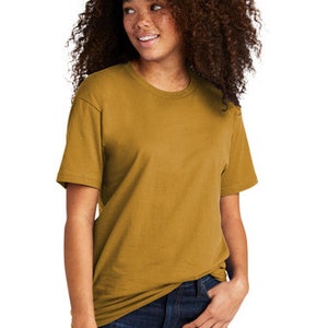 Peut inclure: Un t-shirt &agrave; manches courtes jaune moutarde avec un col rond. Le t-shirt est fait d'un tissu doux et confortable, parfait pour tous les jours.