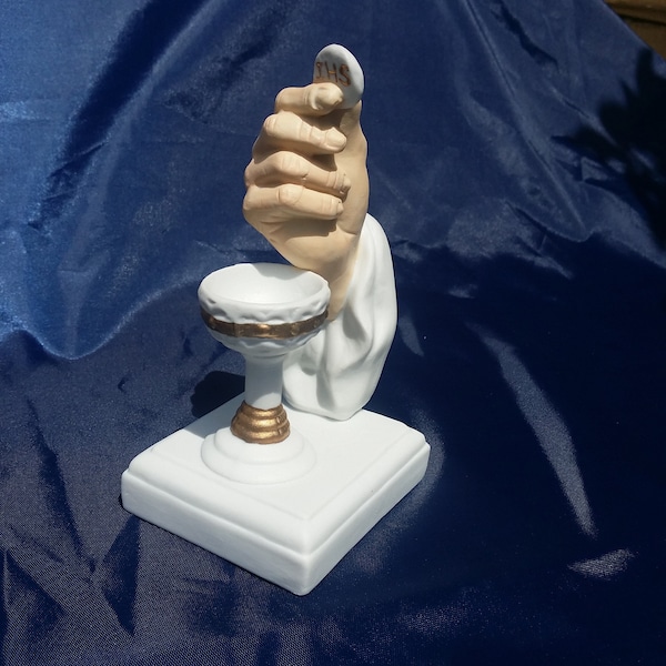 Main avec figurine en céramique eucharistique et calice, gâteau de communion, décorations d’église, mains de prêtre, confirmation, cadeau du clergé, vintage