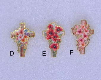 May include: Three decorative crosses with floral designs. The crosses are gold-toned with colorful flowers, including red poppies and pink blooms. Each cross has a different floral arrangement. Letters D, E, and F are printed below each cross.