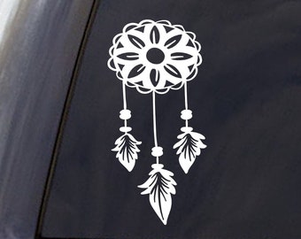 May include: White vinyl decal of a dreamcatcher with feathers. The decal is on the back window of a black SUV.