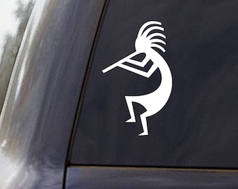 May include: White vinyl sticker of a Kokopelli, a Native American flute player, on a black car window.