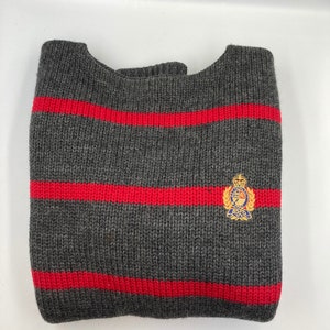 May include: Grey and red striped jumper with a small embroidered logo that says "Polo" in blue and gold.
