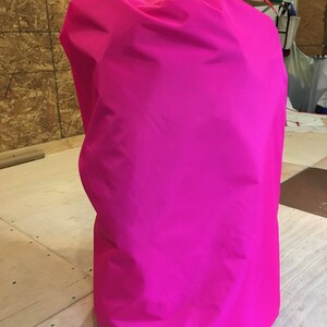 May include: A bright pink fabric storage bag with a drawstring closure.