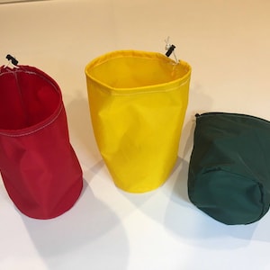 May include: Three drawstring bags in different colors: red, yellow, and green. The bags are made of a soft, fabric material and have a drawstring closure at the top.