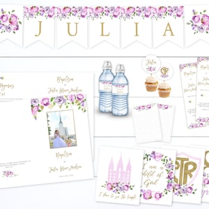 May include: Purple and gold baptism decorations with floral accents. The decorations include a banner with the name "JULIA", water bottles, a program, a hymn, and a sign that says "I am a child of God".