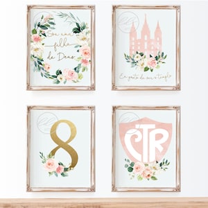 May include: Four framed prints with a light blue background and floral accents. The prints feature the text "Sou uma filha de Deus", a pink temple silhouette, the number 8, and the letters "CTR".