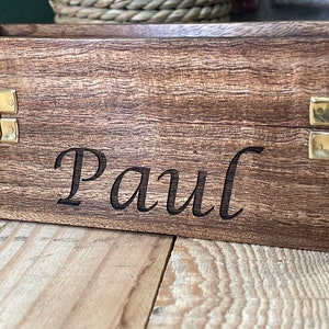 May include: A wooden box with brass clasps and the name "Paul" engraved on the front.