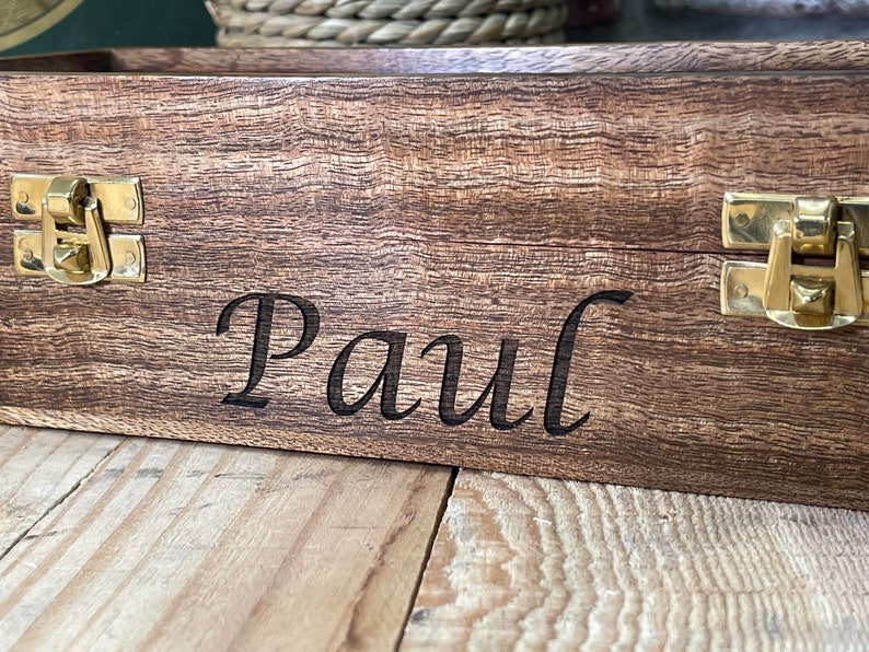 May include: A wooden box with brass clasps and the name "Paul" engraved on the front.