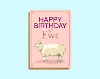 May include: A pink birthday card with a brown border and gold accents. The card features a white sheep with a pink nose and the text "Happy Birthday to Ewe".
