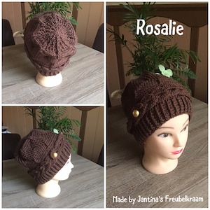 Op de afbeelding: Bruine gebreide beanie met een gouden knoop. De beanie is te zien op een mannequinhoofd en op een tafel. De tekst "Rosalie" en "Made by Jantina's Freubelkraam" is zichtbaar in de afbeelding.