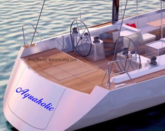 May include: A white sailboat with a wooden deck and the text "Aquaholic" in blue lettering on the back of the boat.