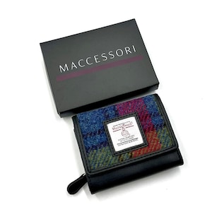 May include: A black leather trifold wallet with a colorful plaid pattern and a label that reads "Hand Woven Cloth Harris Tweed Outer Hebrides Scotland 100% Pure New Wool".