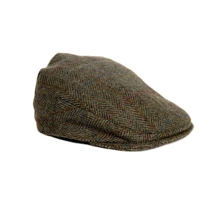 Puede incluir: Gorra plana de tweed marrón con un patrón de espiga. La gorra presenta un diseño clásico con una corona redondeada y una pequeña visera rígida. La tela tiene motas azules, rojas y naranjas.