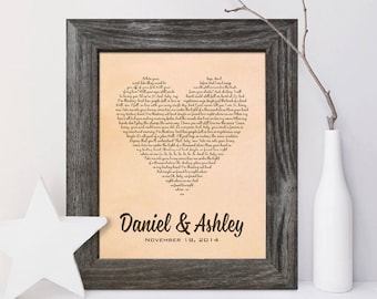 May include: A framed print with a heart-shaped design made of song lyrics. The print is on a light brown background with dark brown text. The names "Daniel & Ashley" and the date "November 18, 2014" are printed below the heart.