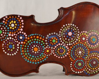 May include: A brown violin with a colorful dot pattern painted on the body. The dots are arranged in a swirling pattern of circles and semi-circles. The colors include pink, blue, green, orange, yellow, and white.