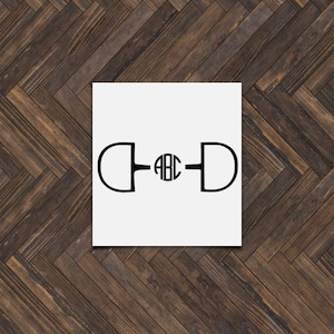 May include: A black and white monogrammed equestrian bit with the letters "ABC" in the center.
