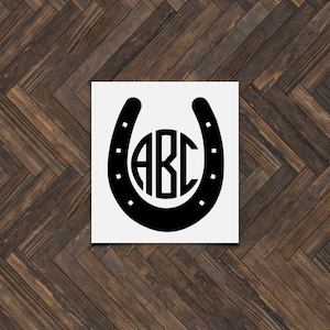 May include: Black horseshoe silhouette with a circle in the center containing the letters "ABC".